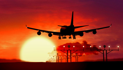 Airplane silhouette landing on sunset