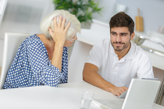 young man and his grandma working together on laptop
