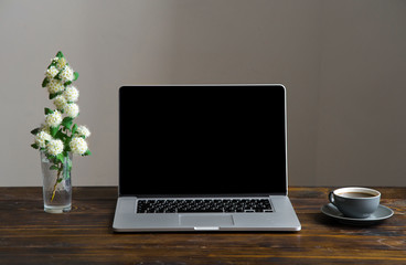 Fototapeta premium Mock up with laptop, coffee cup and white spring flowers on vintage wooden table