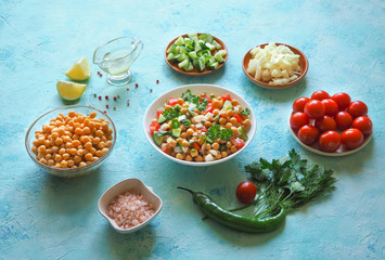 Salad with chickpeas. Set of sliced vegetables and chickpeas on a blue background with copy space.