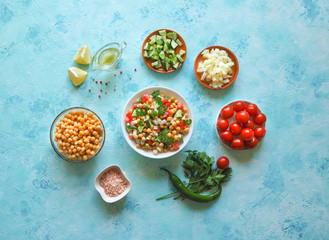 Salad with chickpeas. Set of sliced vegetables and chickpeas on a blue background with copy space.