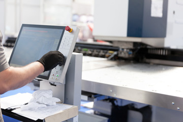 Man working at computer numerical control - CNC machine