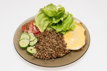 healthy home food based on buckwheat, egg, tomatoes, cucumbers, lettuce, sesame
