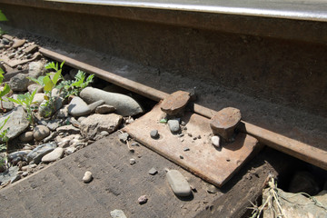 An old railway in the countryside. Fastening the rails to the sleeper with a nail. Details