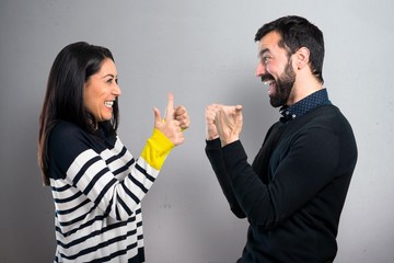 Couple with thumb up on grey background
