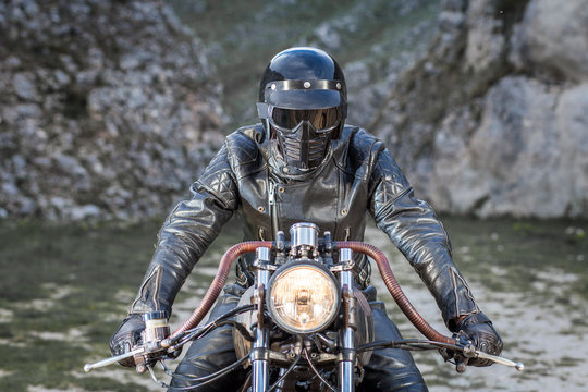 Biker with leather clothes and black mask ride his custom rat motorcycle
