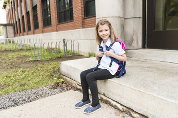 Fototapeta na wymiar Portrait of cute girl with backpack outside of school