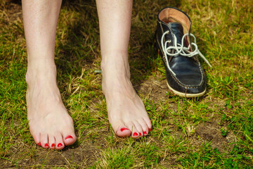 Woman feet on green grass ground
