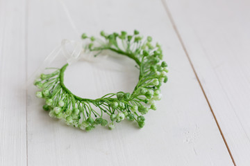 green spring wreath on his head. decoration for the head. wreath of flowers. a wreath of baby's breath