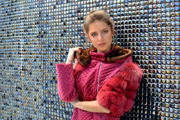 Chica joven posando con una chaqueta con capucha en piel de vison y zorro. 