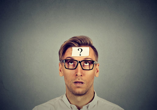 thinking man in glasses with question mark looking up
