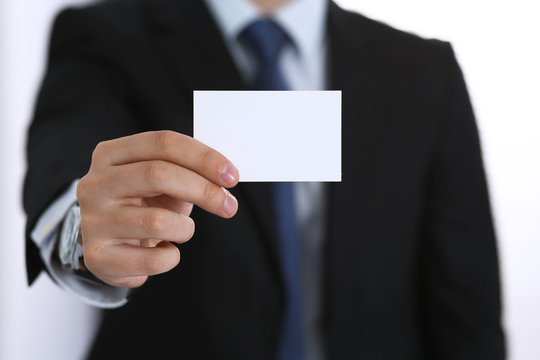 Businessman's hand holding business card with empty space