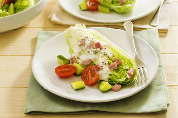 Classic wedge salad with tomatoes, cucumber, bacon and blue cheese dressing 
