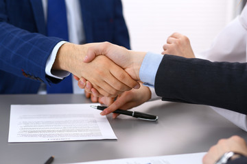 Business people shaking hands, finishing up a papers signing. Meeting, contract and lawyer consulting concept