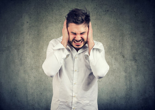Frustrated man suffering with loud noise