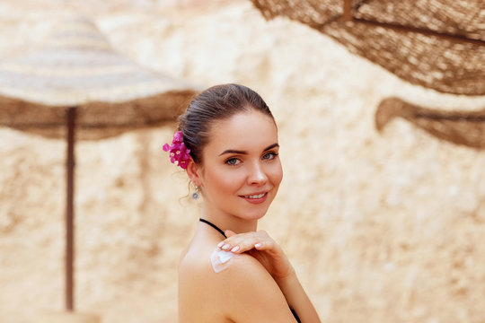 Woman Applying Sunscreen Creme on  Tanned  Shoulder. Skincare. Sun Protection. Girl Using Sun cream Lotion on Back