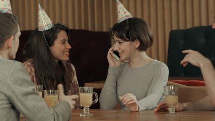 Young girl celebrating birthday in cafe, talking on cell phone