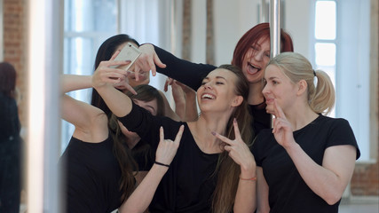 Group of beautiful young women taking a selfie after a pole dance class