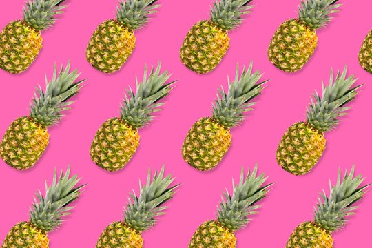 Colorful fruit pattern, Pineapples on a bright pink background. Top view.