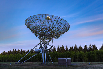 The Westerbork Synthesis Radio Telescope (WSRT) during dusk, with a light cloudy sky and stars a little visible