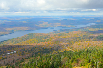 Fototapeta na wymiar Lake Tremblant and Mont-Tremblant village in fall with fall foliage, from top of Mont Tremblant, Quebec, Canada.