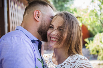 Obraz premium Young man whispering to woman or girlfriend, boyfriend telling surprising secret to his girl, man says nice words to his girlfriend, girl is smiling or laughing