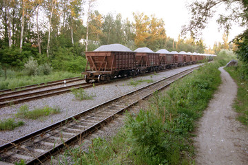 Fototapeta na wymiar Freight wagons filled with sand, in the summer in the forest