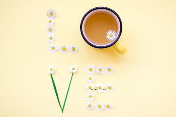 Love message written with flowers on yellow background. Individual Love concept.