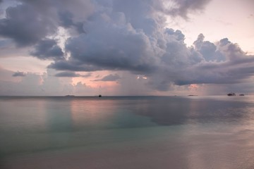 Gorgeous view of sunset on Indian Ocean, Maldives. Blue water and blue sky with white clouds. Amazing nature backgrounds.
