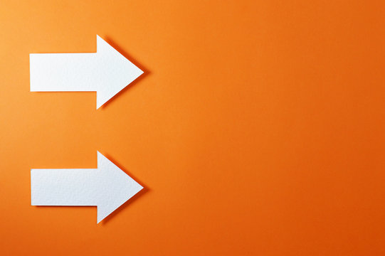 two solid arrows on orange background