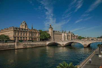 Obraz premium Bridge over the Seine River and the Conciergerie building with sunny blue sky at Paris. Known as the “City of Light”, is one of the most impressive world’s cultural center. Northern France.