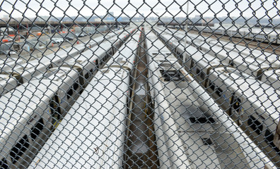 View of trains and rail yard from behind chainlink fence