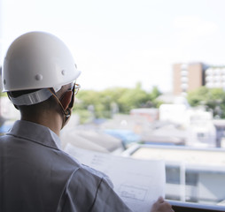 設計図面を見るヘルメットの男性