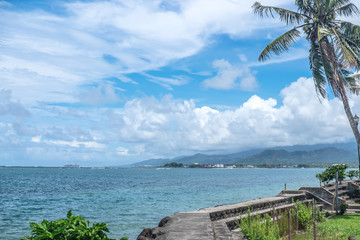 Apia harbour and waterfront, with commercial shipping port and container ship in background -...