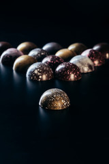 closeup view of pile of chocolate candies on black background