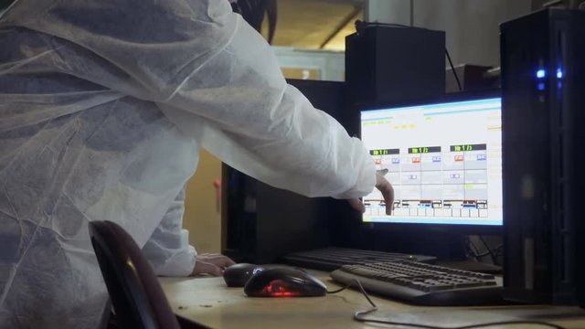 Woman check information about incubators in computer at poultry farm