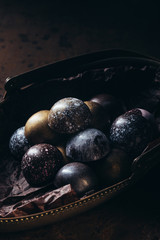 close up view of pile of different chocolate candies in metal basket on wooden table