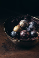 various chocolate candies in metal basket on black background