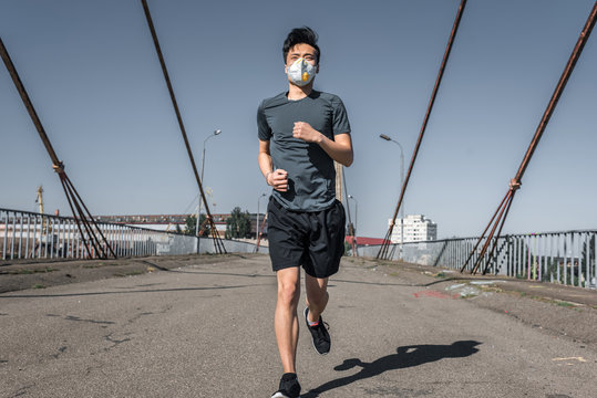 Asian Teenager Running In Protective Mask On Bridge, Air Pollution Concept