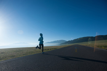 Obraz premium Young fitness sporty woman running on country road