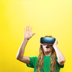 Young man using virtual reality headset on a solid background