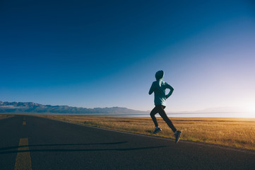 Obraz premium Young fitness sporty woman running on country road