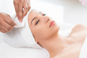 Relaxed young woman lying on spa bed for massage.