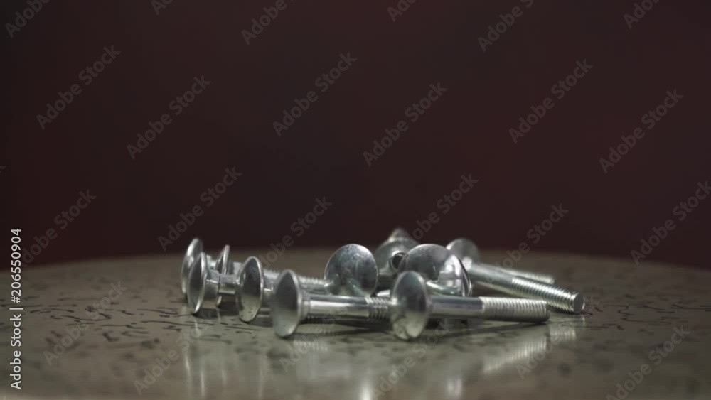 Poster bolts rotating on a metal table and red background.
