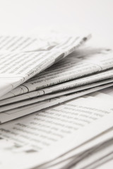 close up of heap of daily newspapers with information, on white
