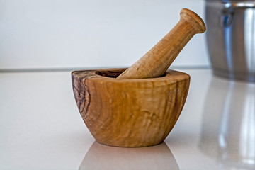 Wooden mortar and pestle on white kitchen counter top