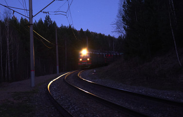 The train rides on the railway tracks at dusk