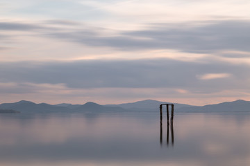 A  minimalistic view of a lake at sunset, with soft light and to