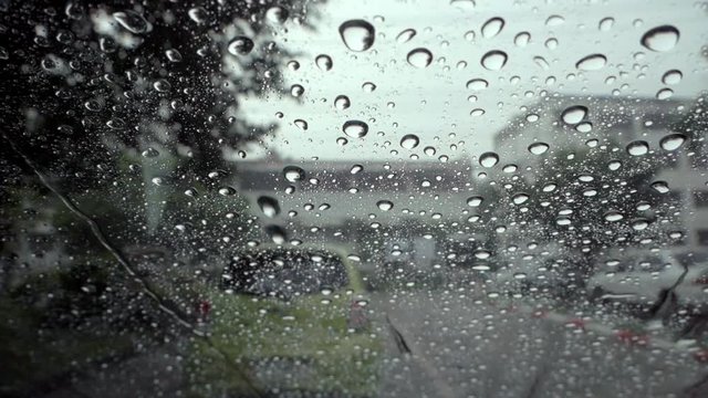 Rain drops on the glass on a rainy day with slow motion.