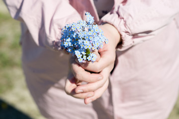 a bouquet of blue wild flowers in women's hands
